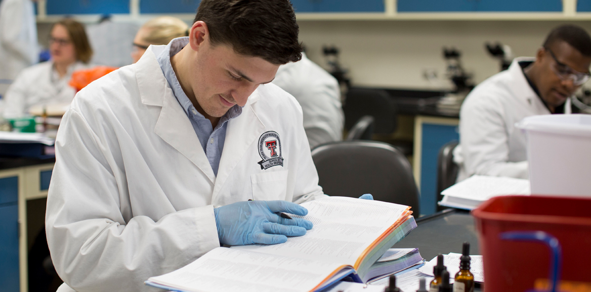 student studying from book in classroom