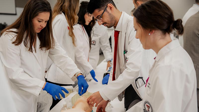 residents working on a medical mannequin