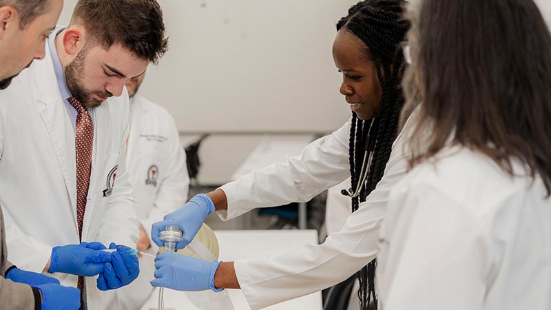 residency students with gloves on holding tubes