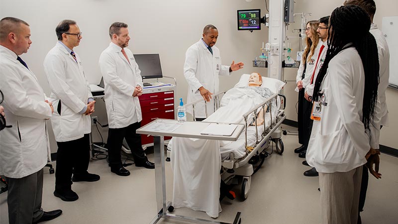 residents standing around a mannequin 