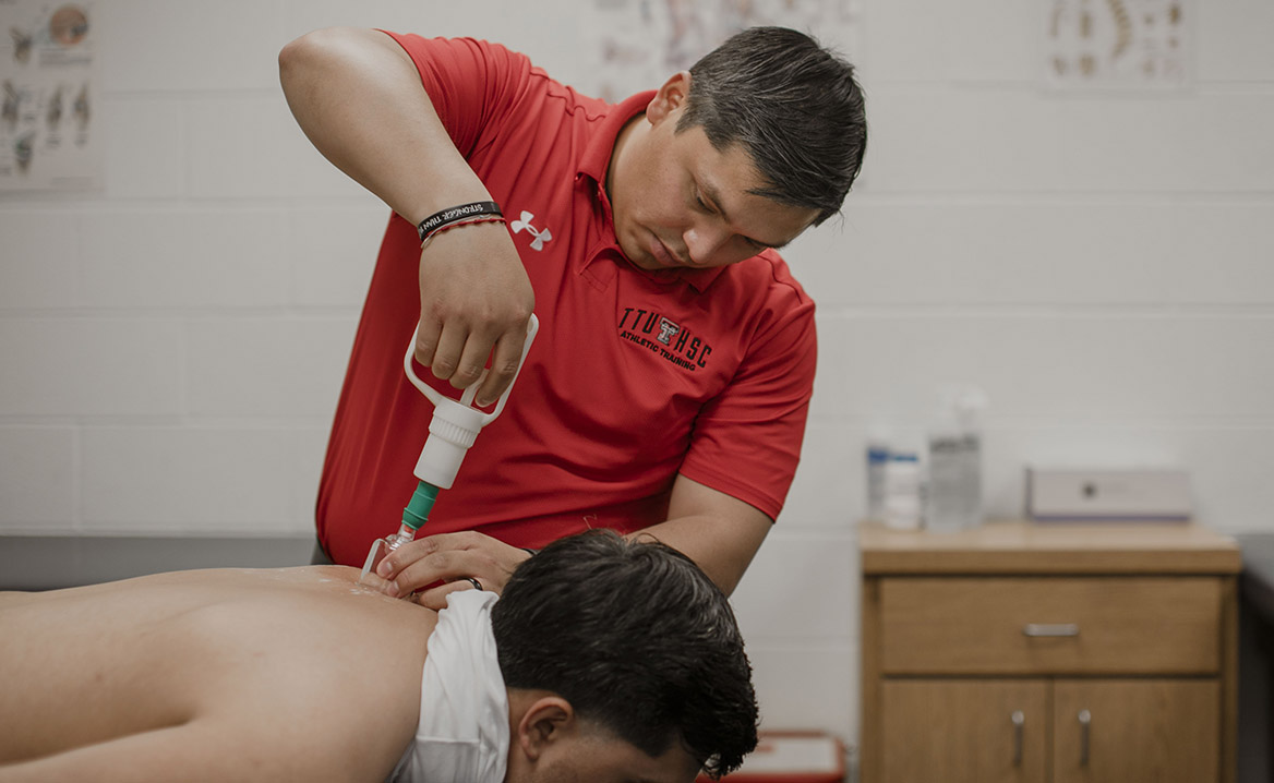 An AT works on an athlete's back and shoulder