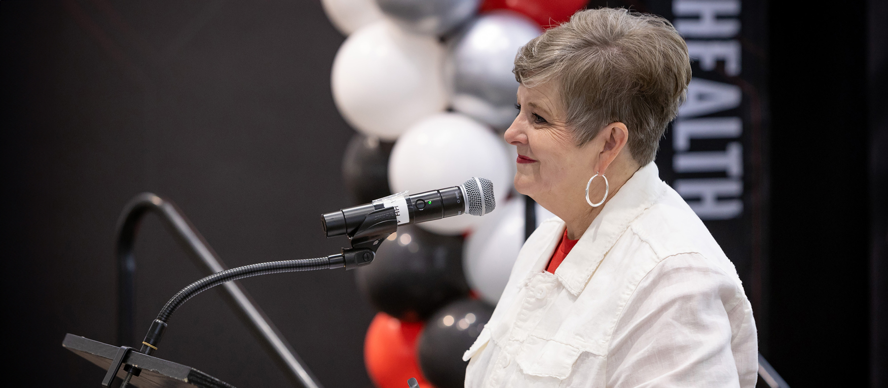 TTUHSC President Rice-Spearman at a podium, smiling at off-screen audience