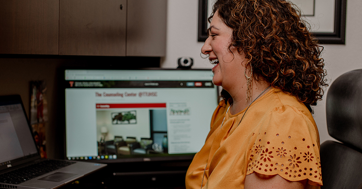 woman in front of a computer smiling