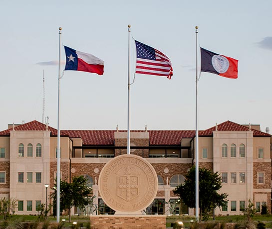 exterior shot of AEC building with flags flying