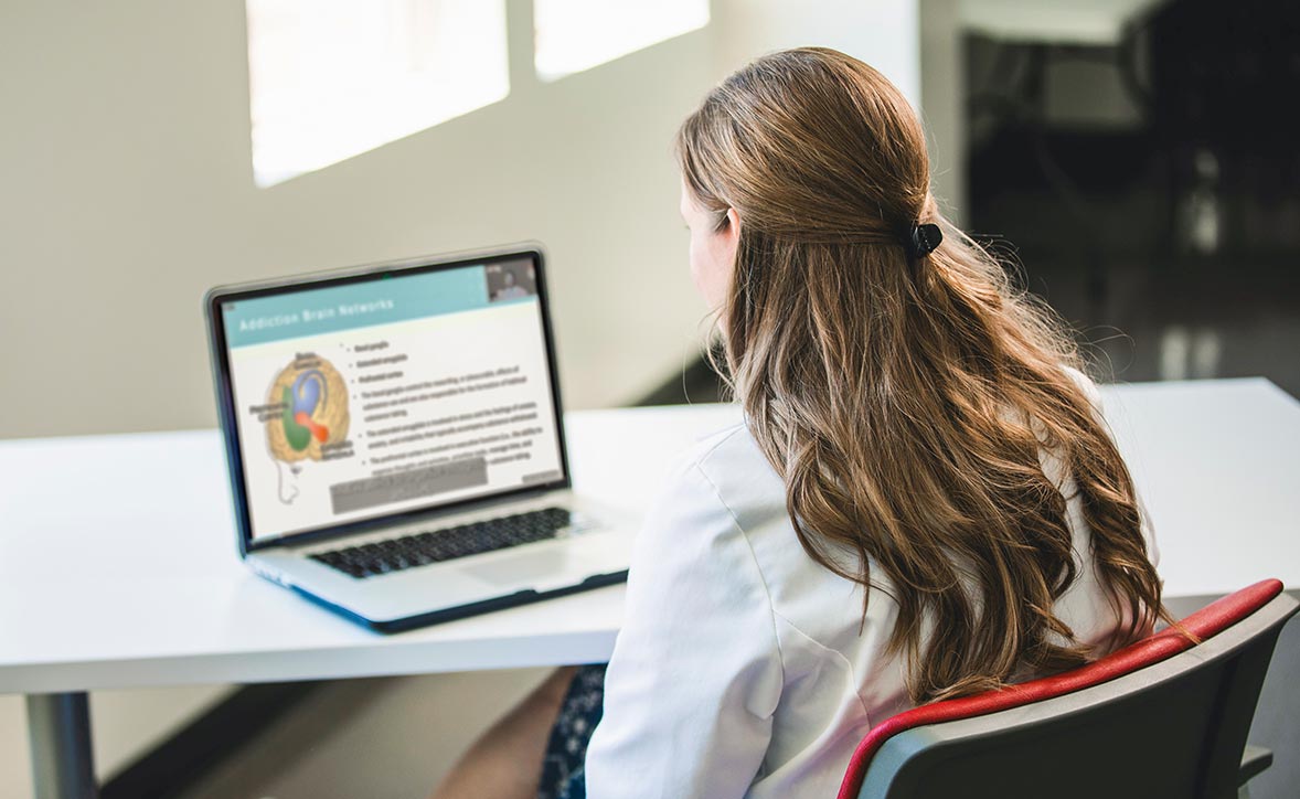 student sitting as desk staring at a computer screen