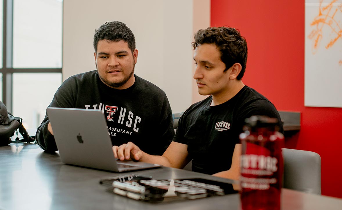 two students sitting down looking at a computer