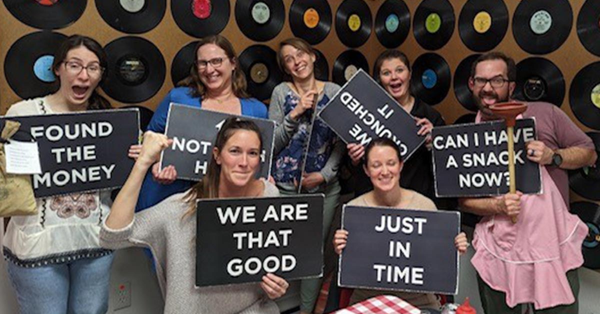 fellowship in escape room holding signs