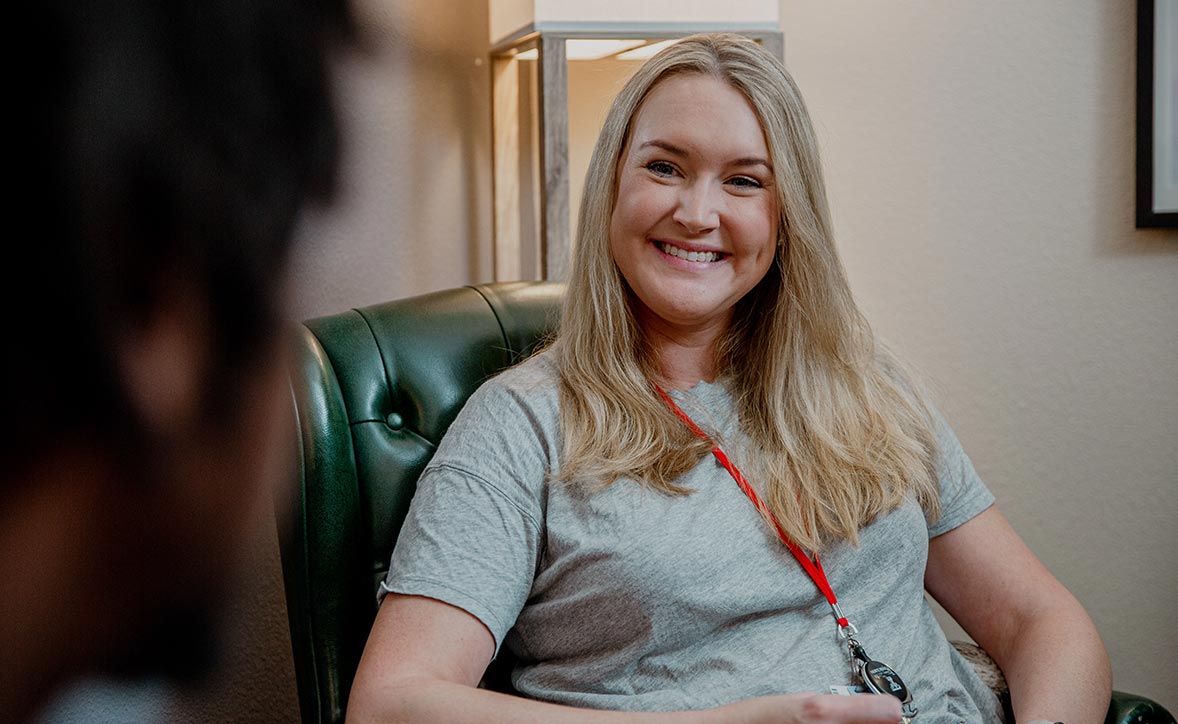 provider sitting in chair facing patient smiling