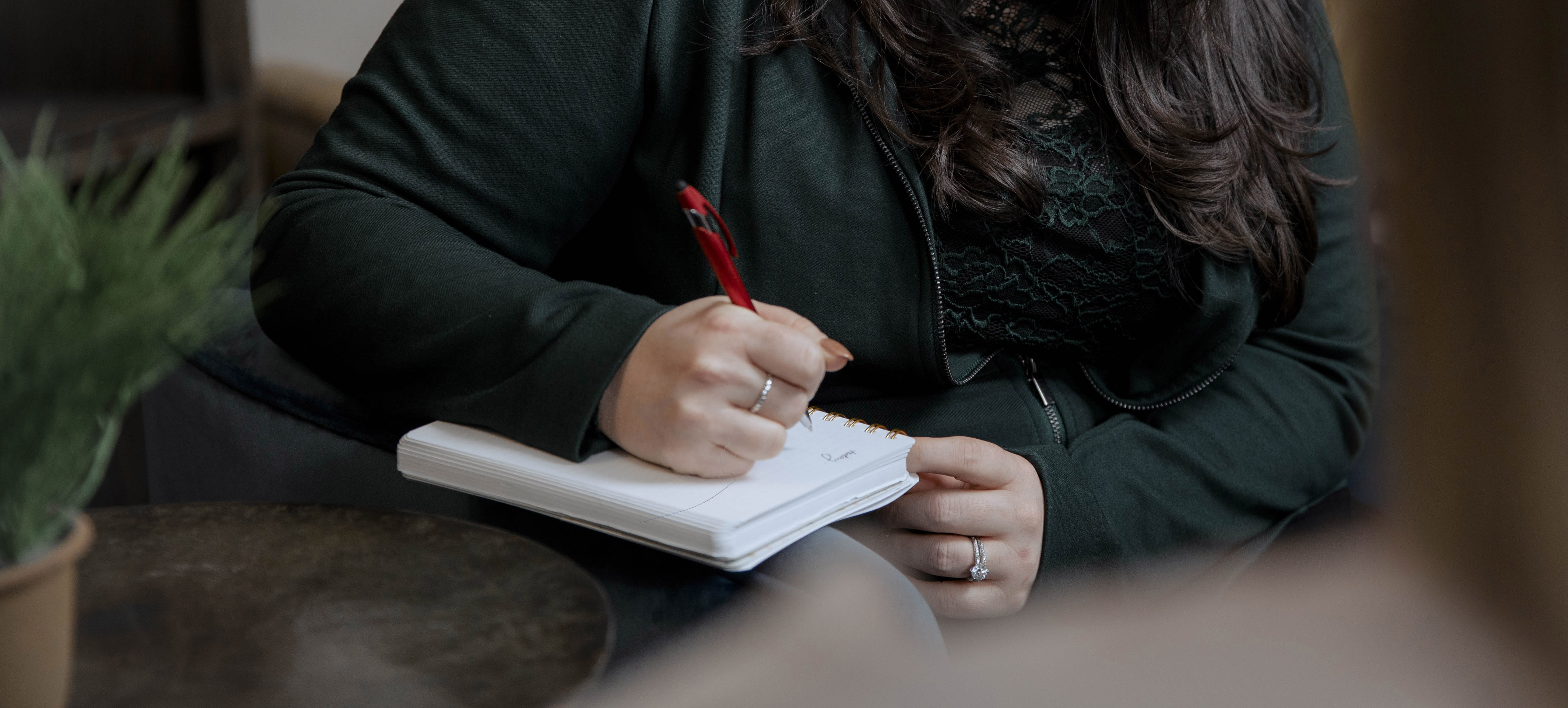 woman writing in a notepad showing on her lap