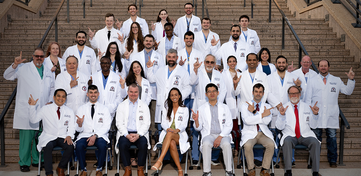 Lubbock Surgical team standing on stairwell with Texas Tech guns up hand motion