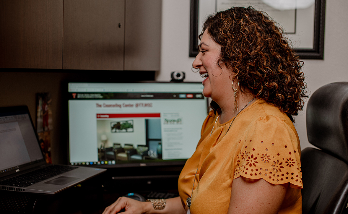 woman in front of a computer smiling