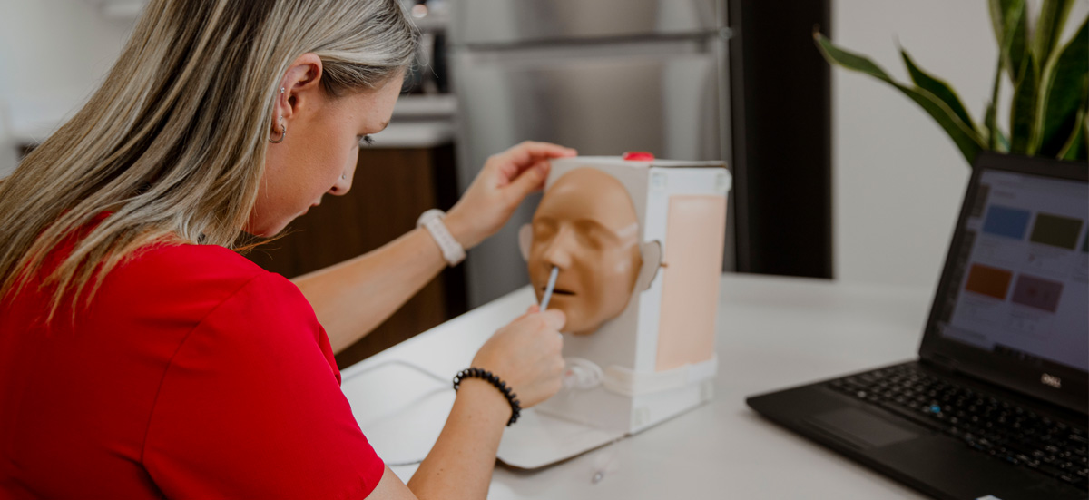 Student with computer working remote with a simulation teaching aid