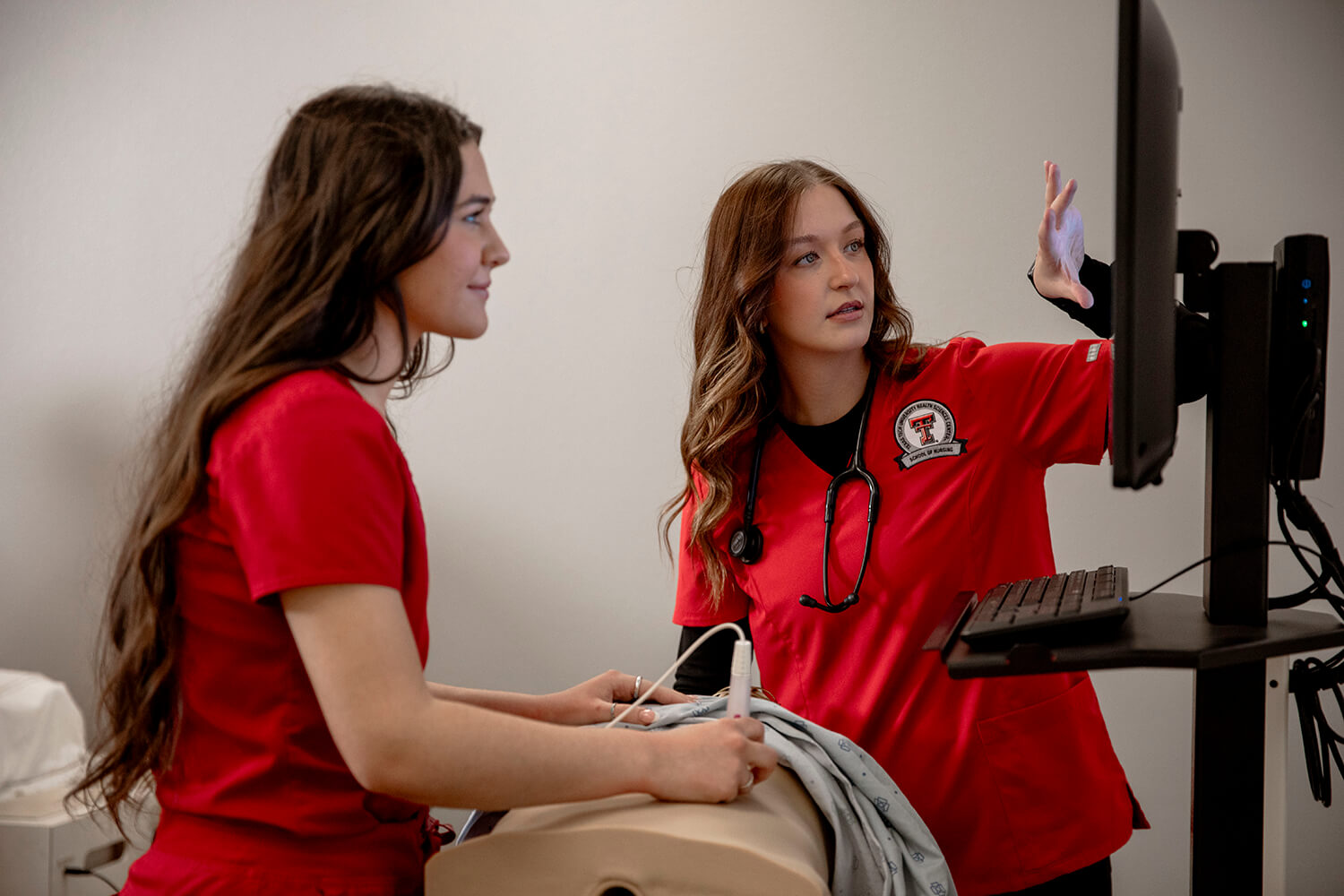 Two nursing students using simulation tools in the lab