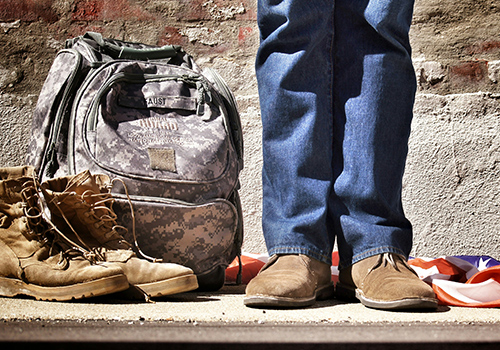 military bag and boots and legs with shoes shown